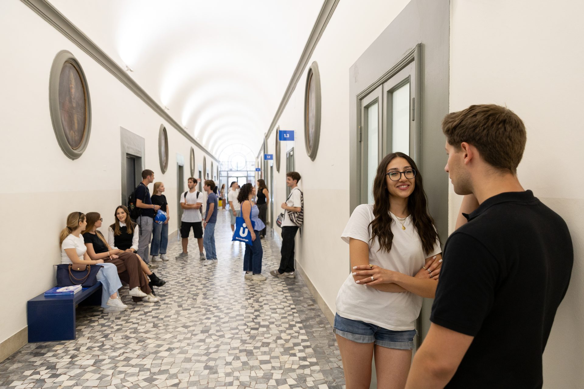 Students talking in the vaulted corridor of the Unicollege Florence Headquarters
