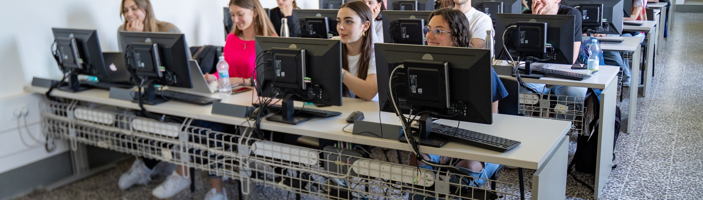 Rows of screens in the Unicollege computer lab during a lesson