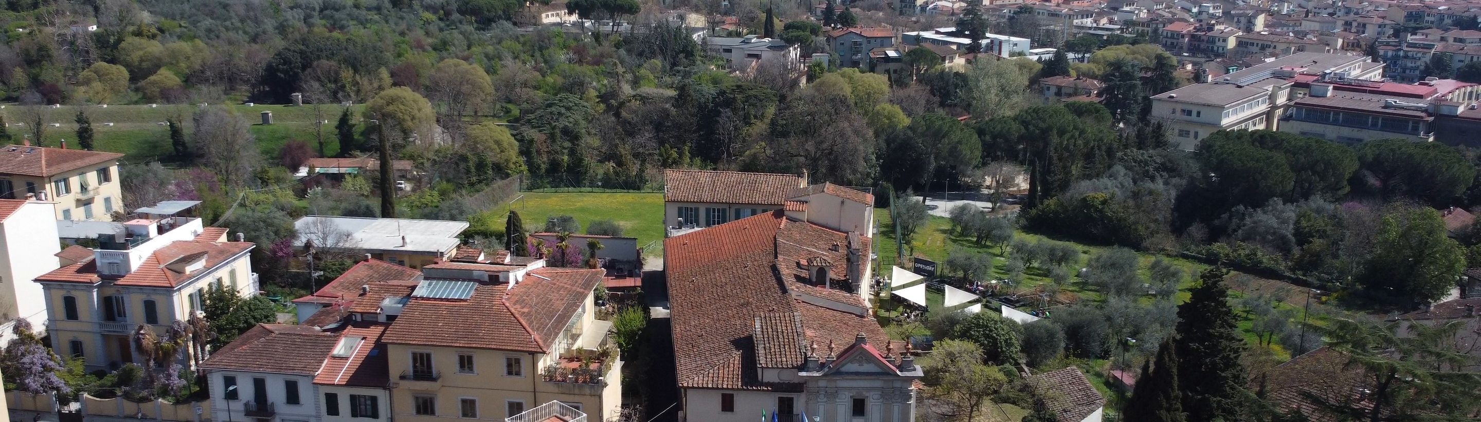 The whole Florence campus from above: church, villa, lawn and the hills of Florence