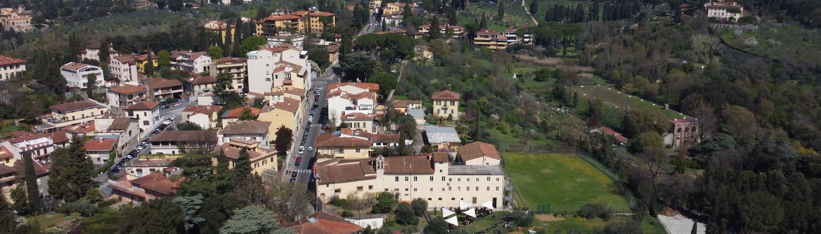 The Florence campus in the green with the hills of Fiesole