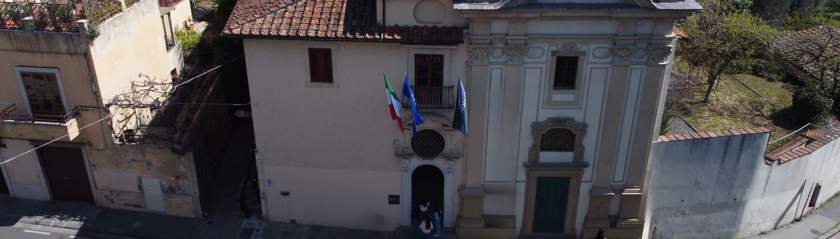 The historic entrance of the Unicollege Florence campus with the Italian and European flags