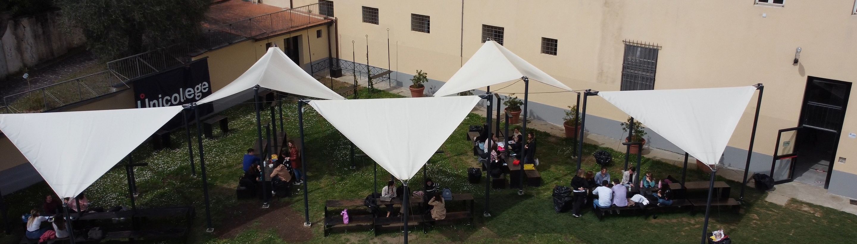 An open-air lesson under the tents in the garden of the Unicollege Florence campus