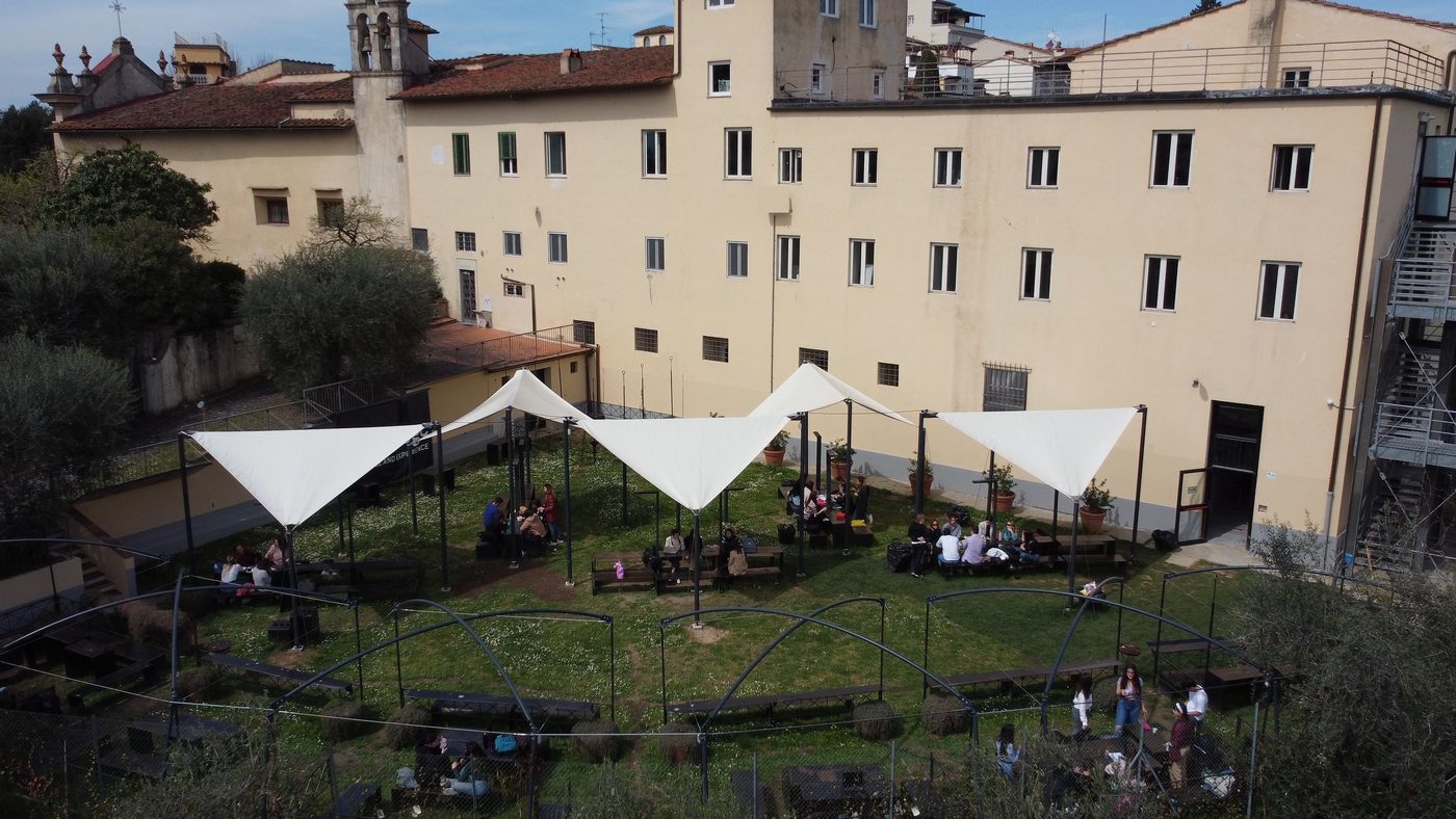 An open-air lesson under the tents in the garden of the Florence campus