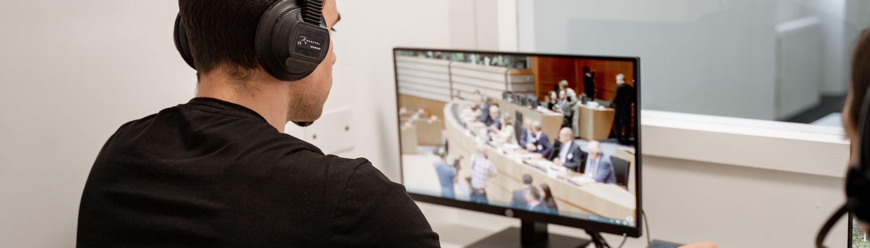 A student with headphones following an online business seminar from the Unicollege lab