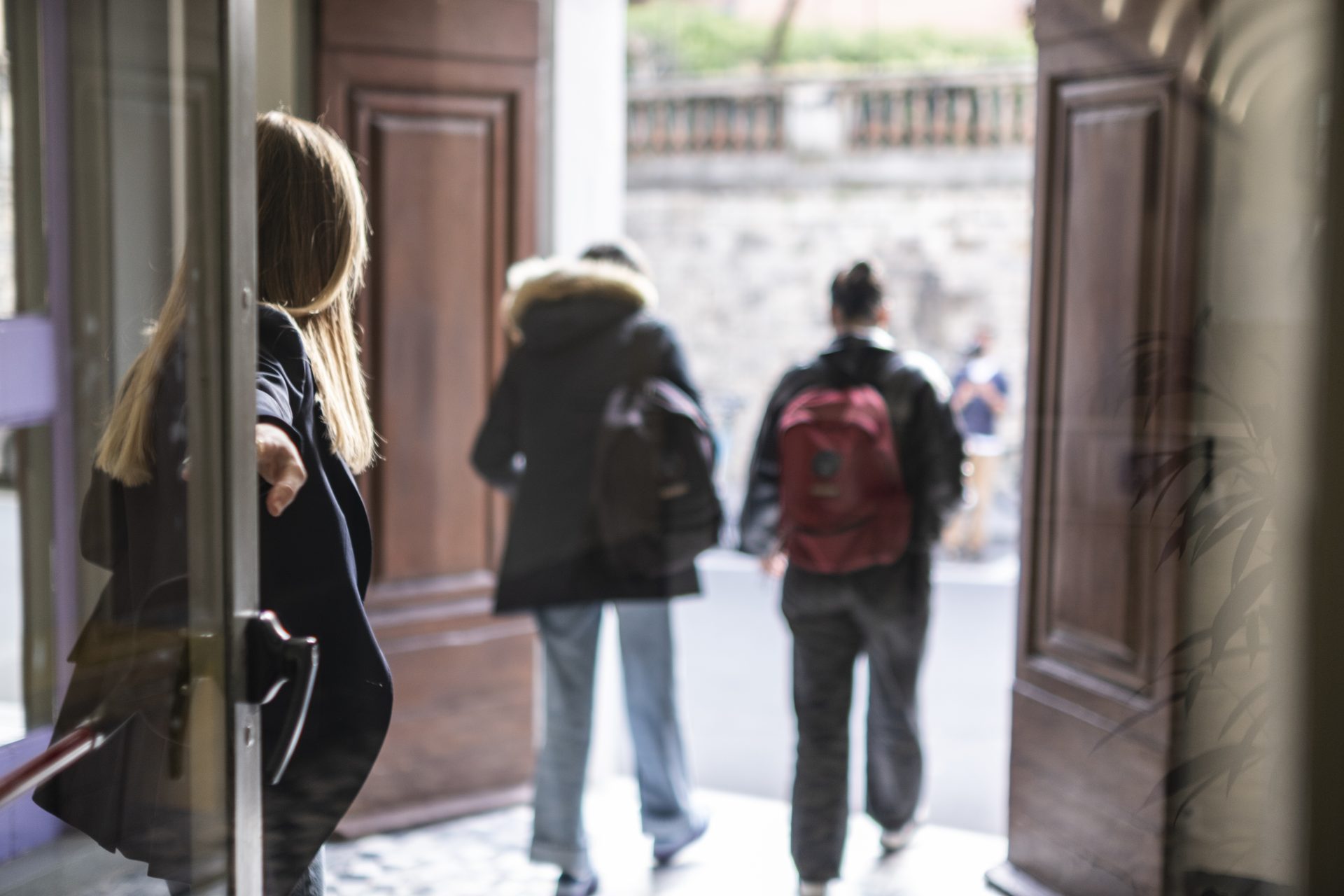 Students passing through the historic entrance of the Unicollege campus