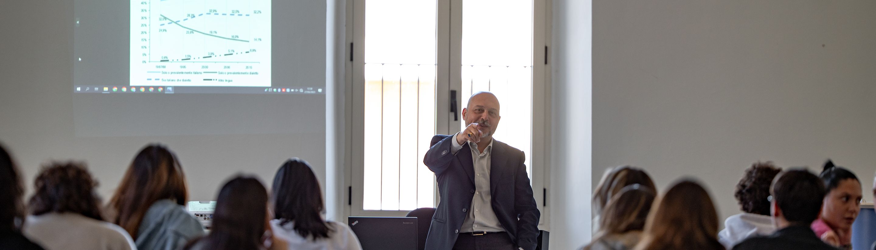 A lecturer with the projector in front of a full Unicollege classroom