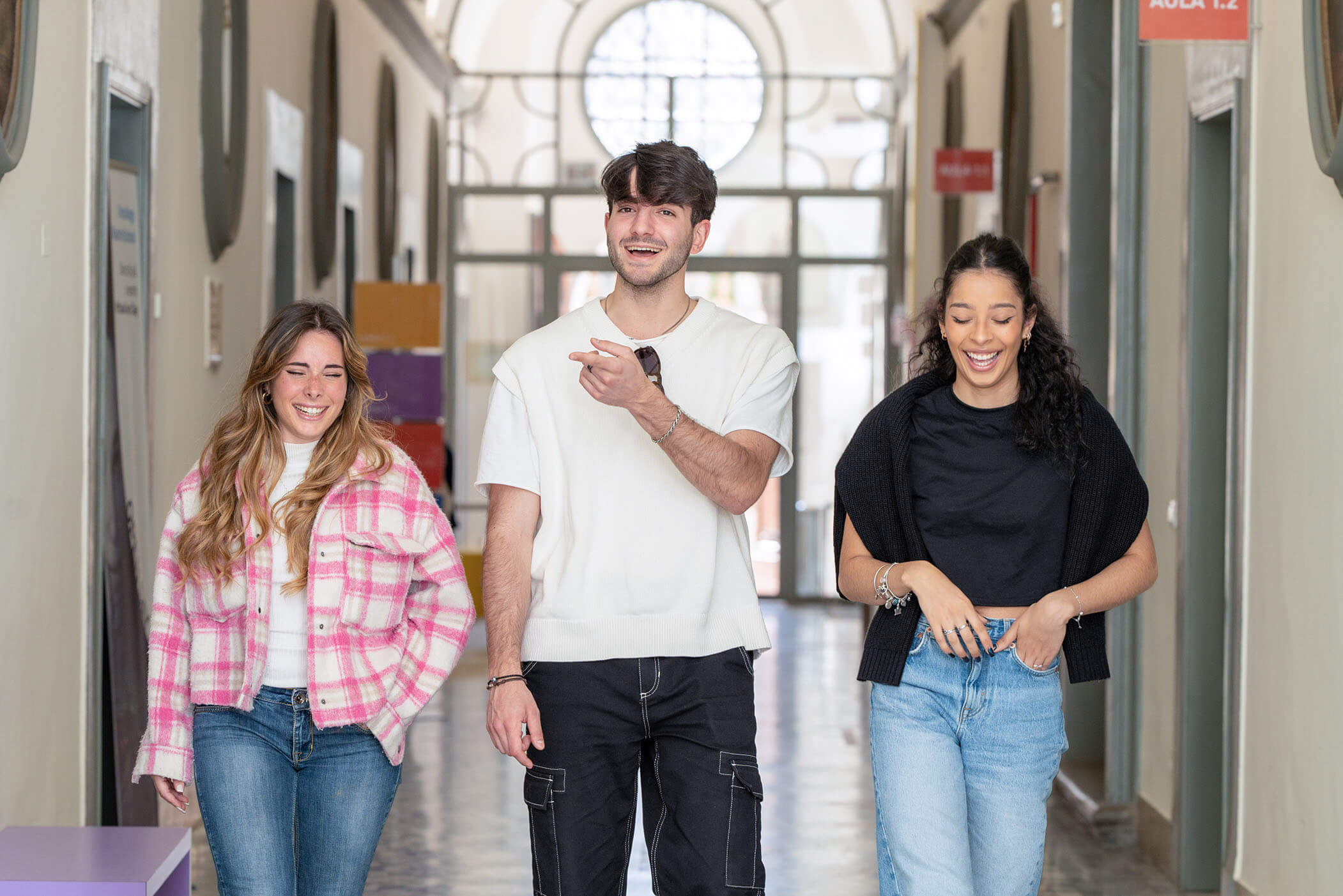 Three students walking along a corridor of the Unicollege campus