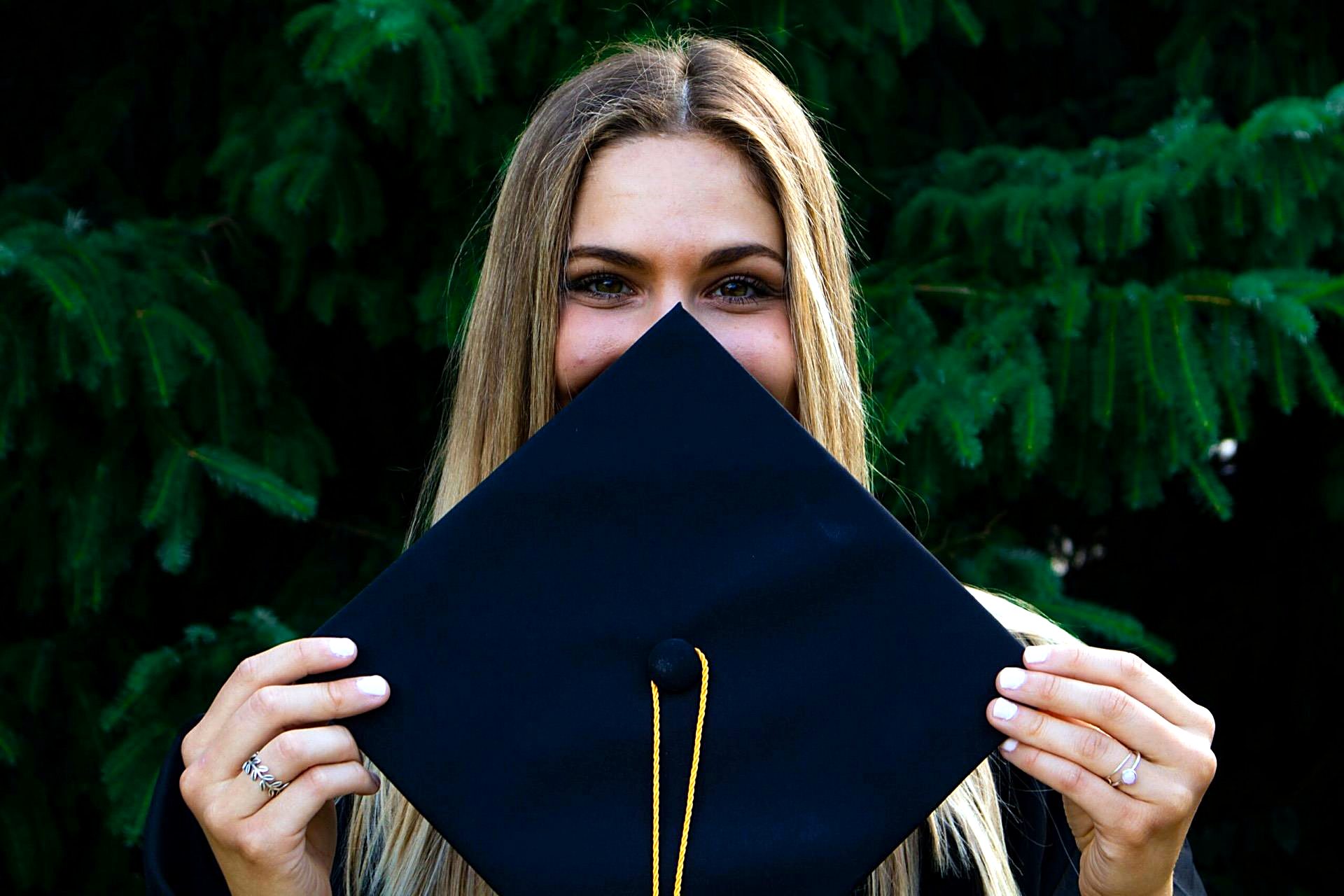 A graduate holding her mortarboard
