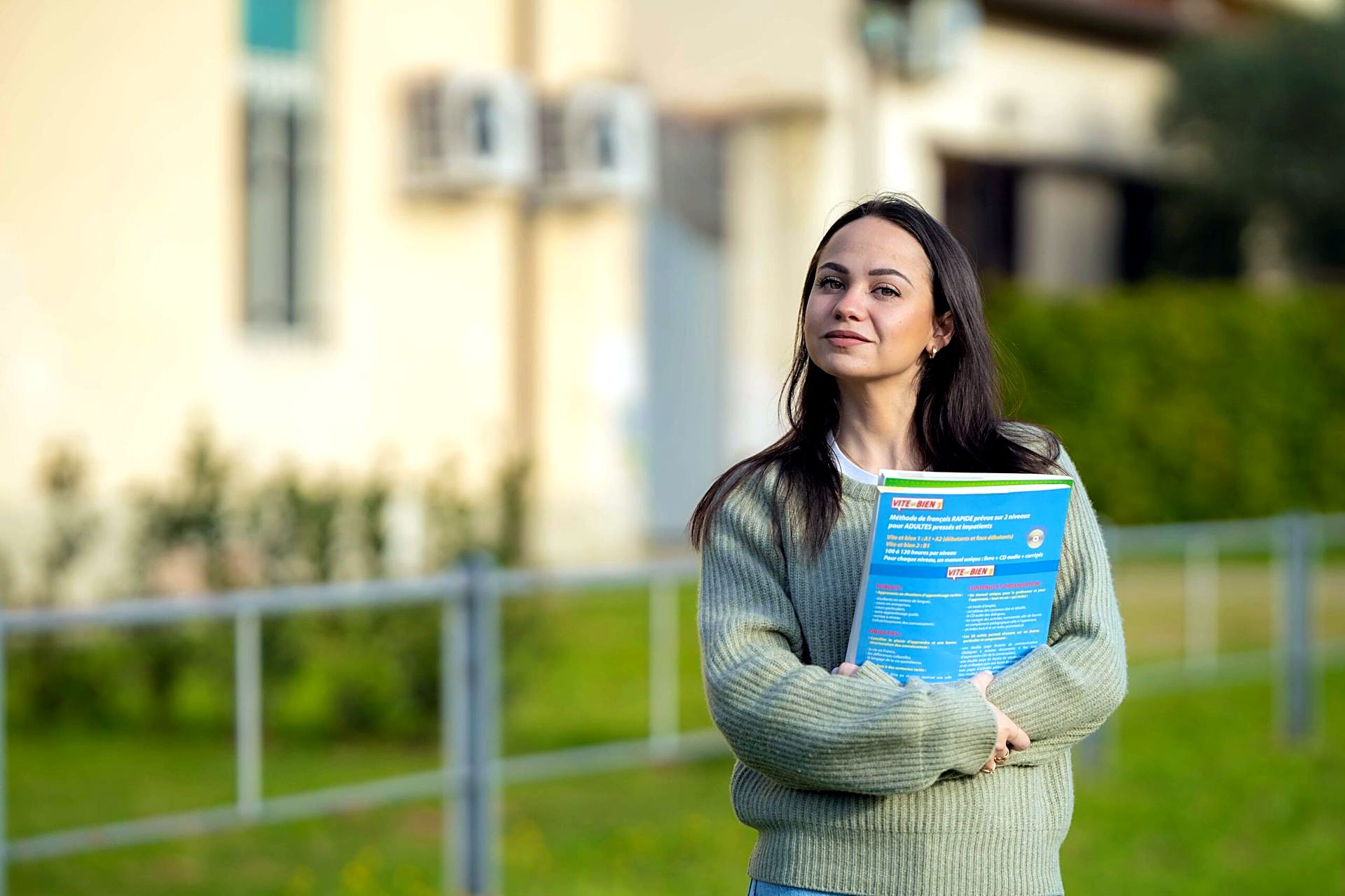 Student holding a Unicollege prospectus outside the campus
