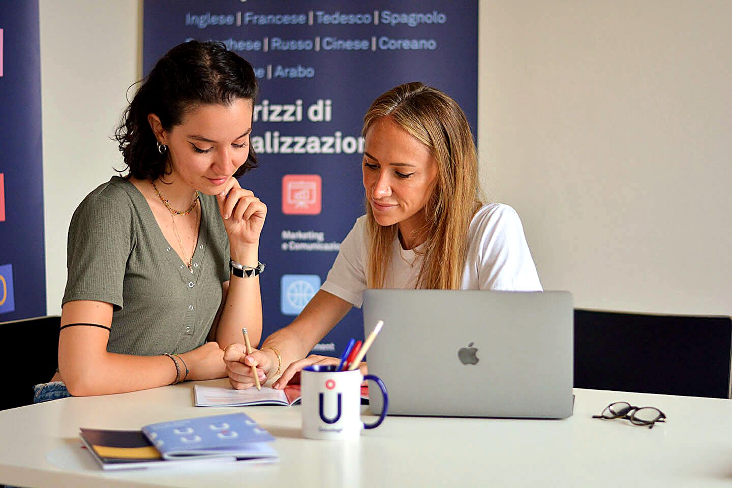 Two Unicollege students working together in front of the languages banner
