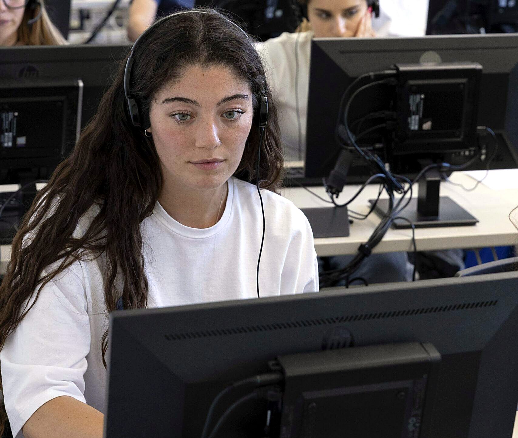 Student wearing a headset in the Unicollege language laboratory