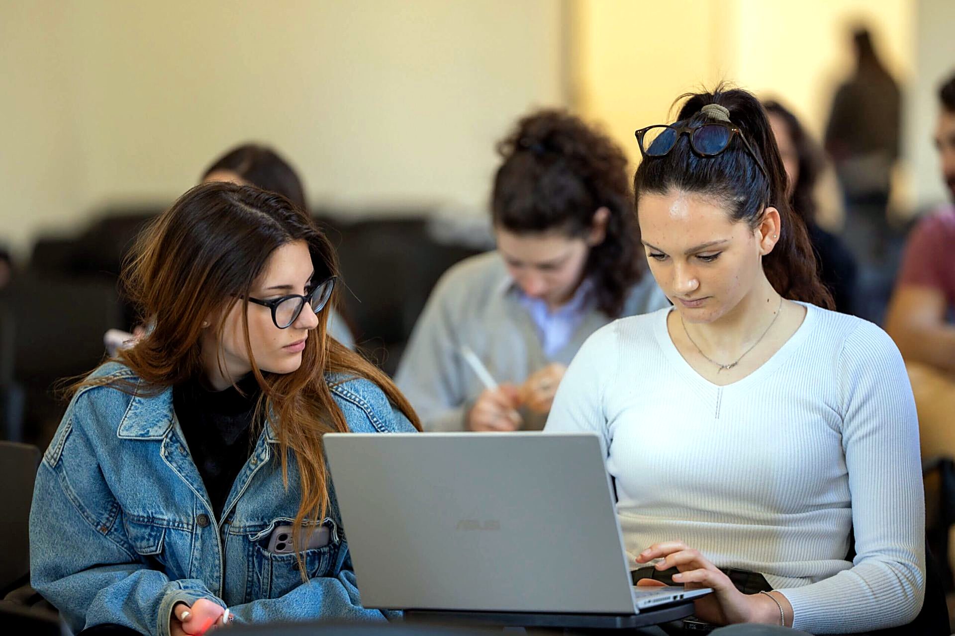 Students working with laptops in a Unicollege study room
